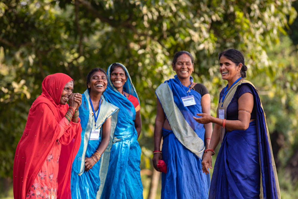 A group of women laughing and talking to each other.