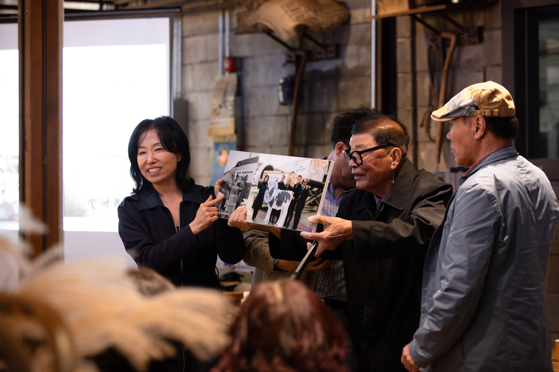 A man and woman hold a framed picture in front of a group.