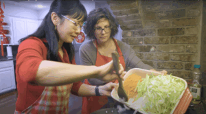 Annie Bergman Giattina Adds julienned vegetables to a hot wok while Pooi Yin Chong stirs.