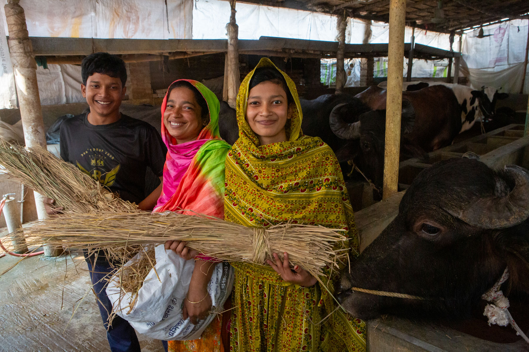 Rebeka and her two children stand beside their buffalo.