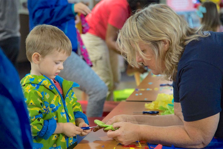 Woman and boy making a craft at a Heifer volunteer event.