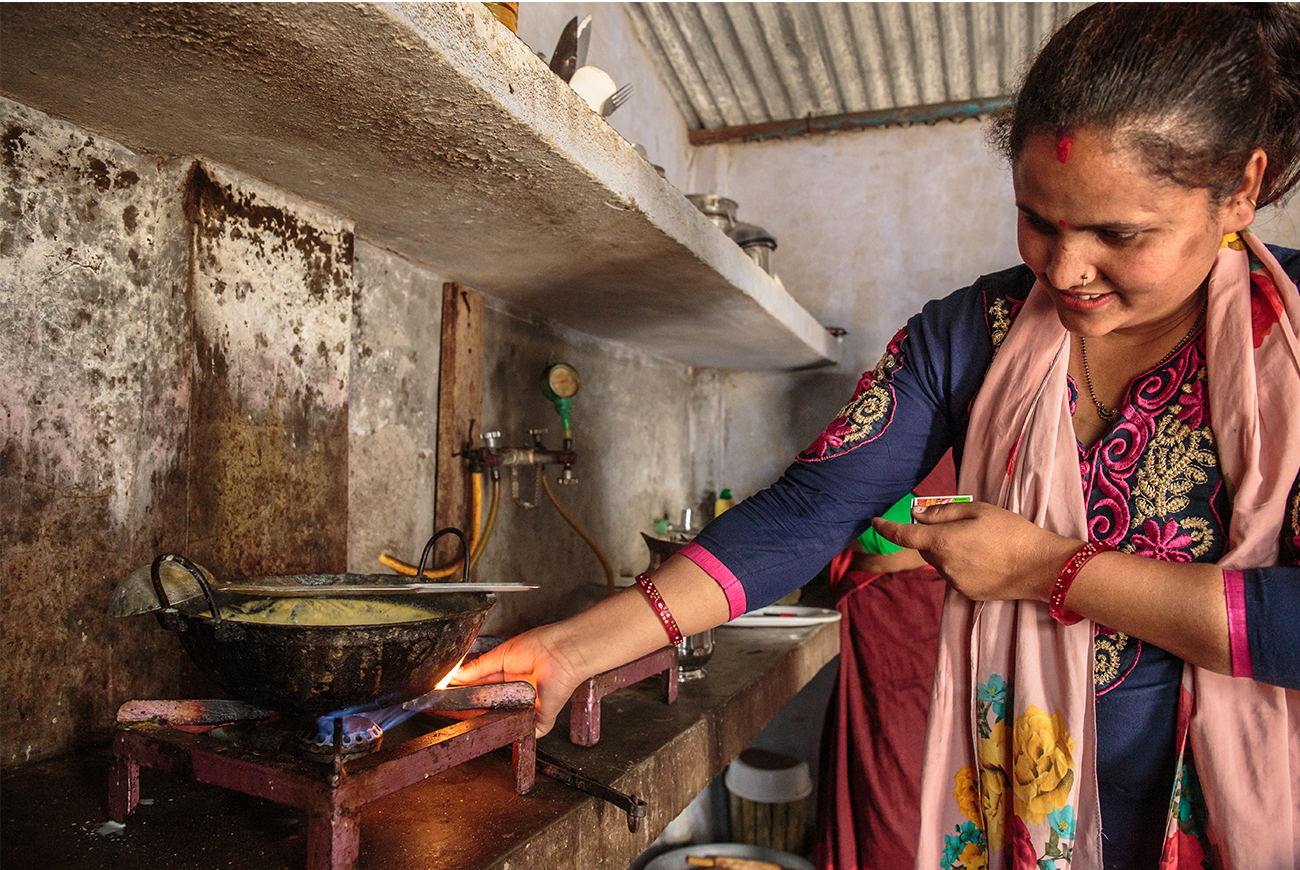 A woman lights her stove.