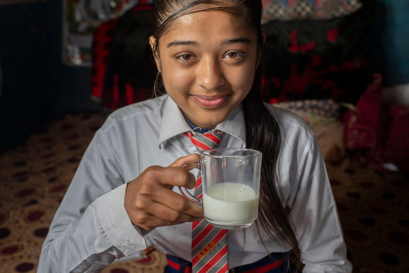 Bishnu's daughter enjoys a glass of milk.