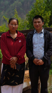 Sushmita and Padam stand together on their farm.