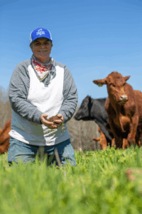 A woman holds a clump of soil in her hands.