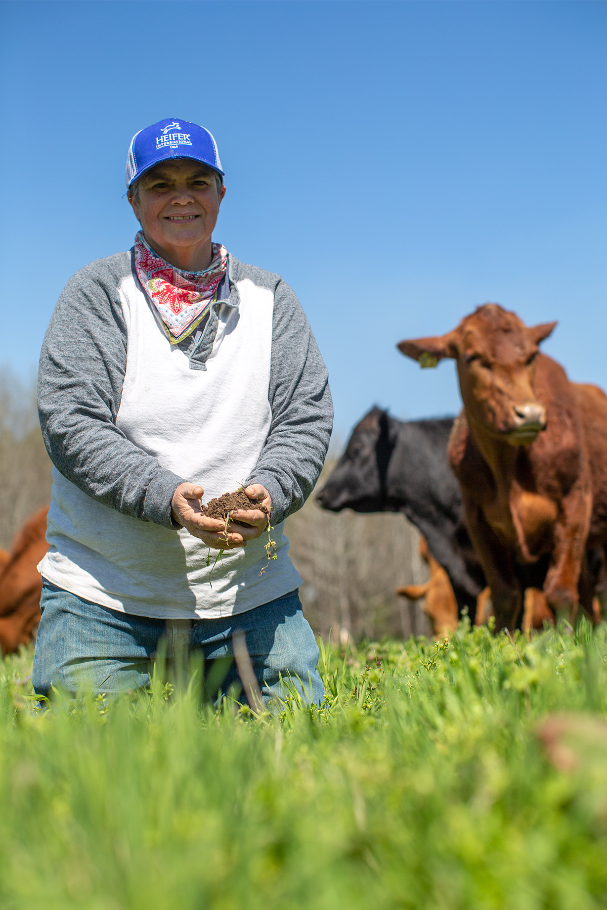 A woman holds a clump of soil in her hands.