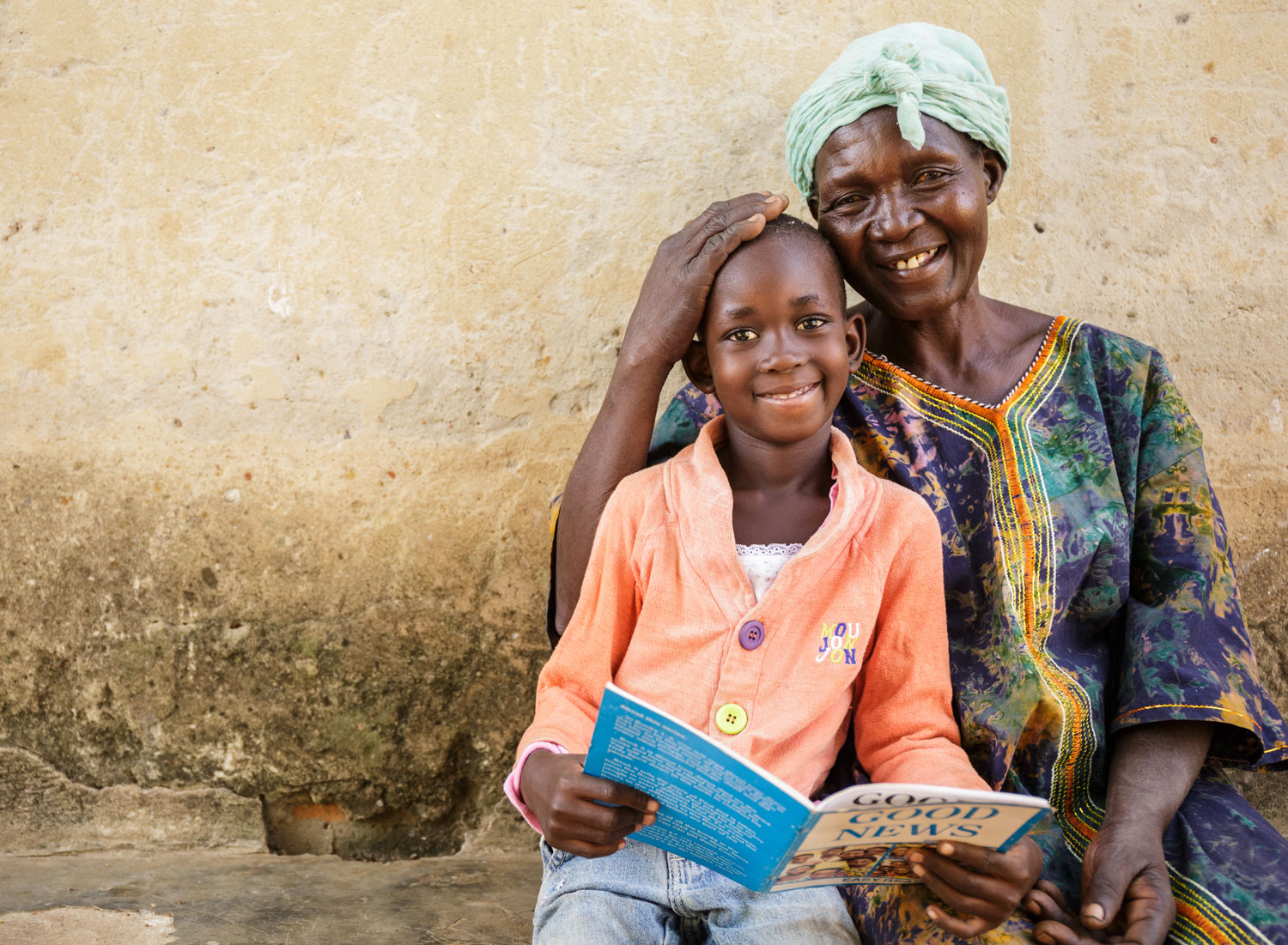Florence sits with her grandchild and a book.