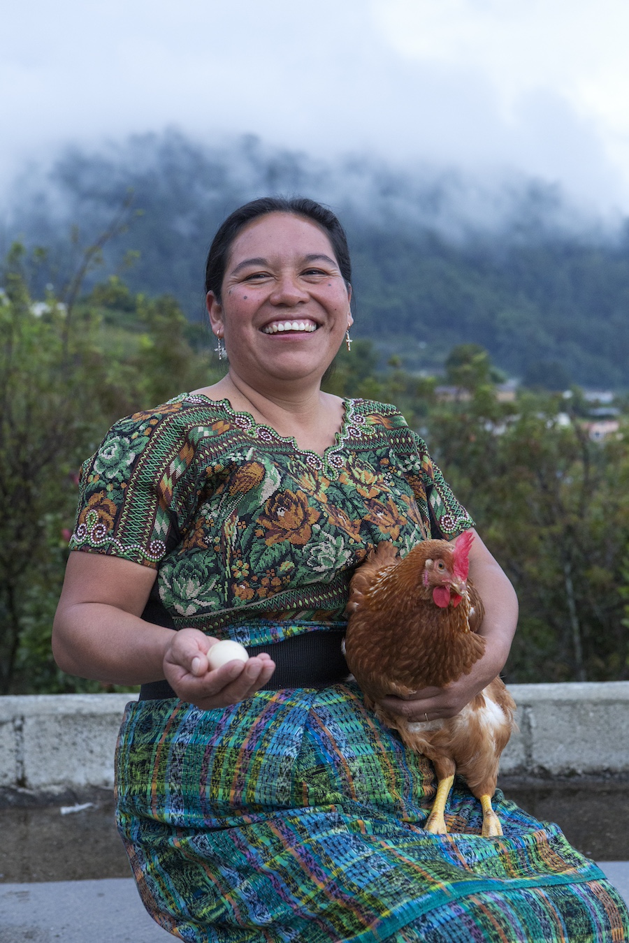Juana holds a chicken in her village.
