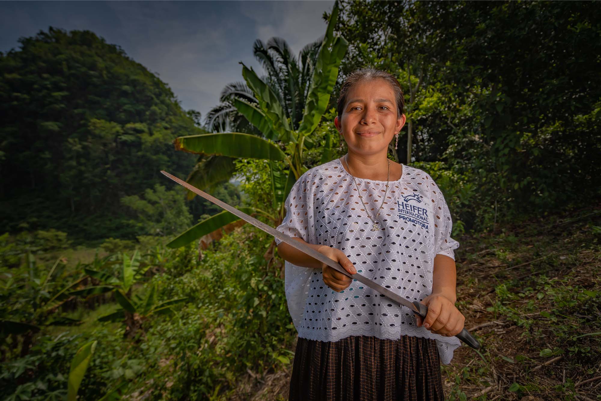 A woman in Guatemala holds a machete.