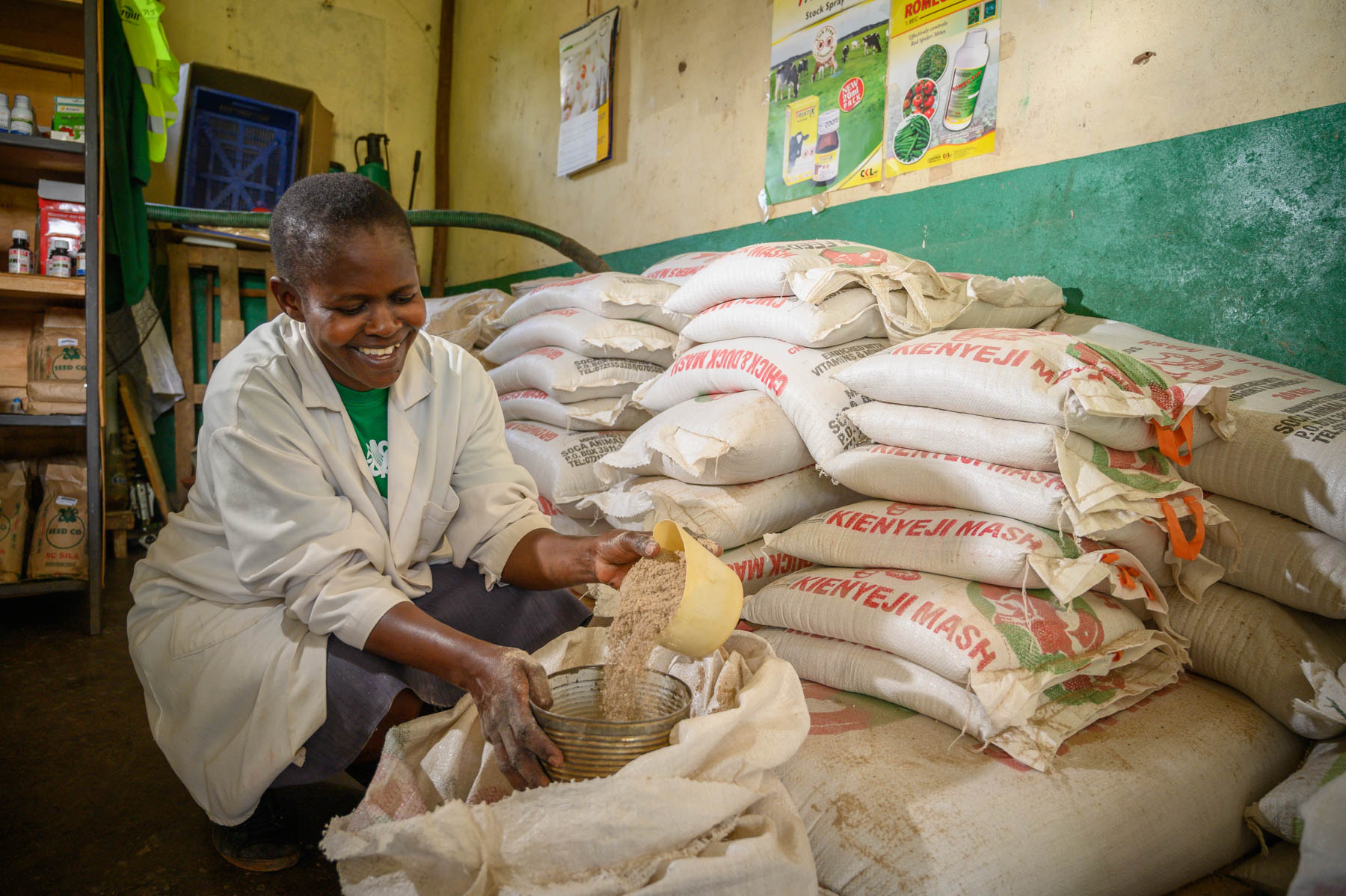 Christine Okode inside her agrovet shop packing some chicken feeds for a customer.