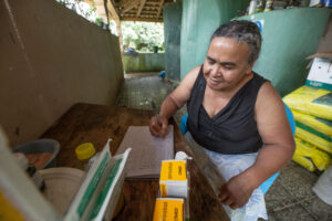 A Honduras woman sitting a desk while reviewing business records.