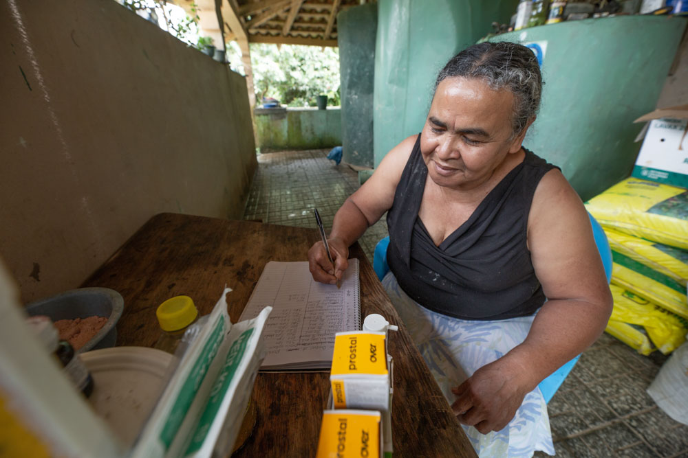 A Honduras woman sitting a desk while reviewing business records. 