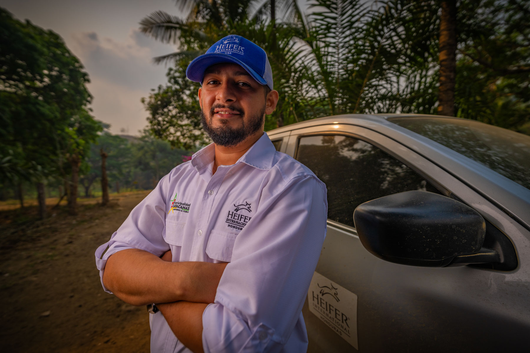 A man stands by a Heifer vehicle.
