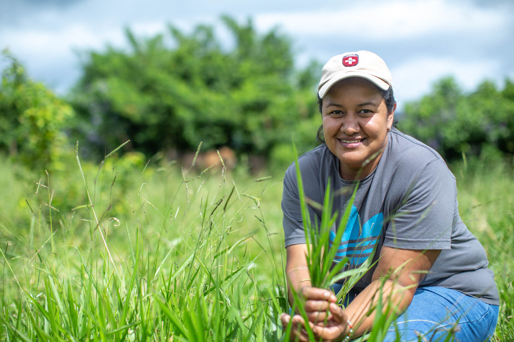 Keyla Aparicio holds and inspect a handful of grass from the pasture.