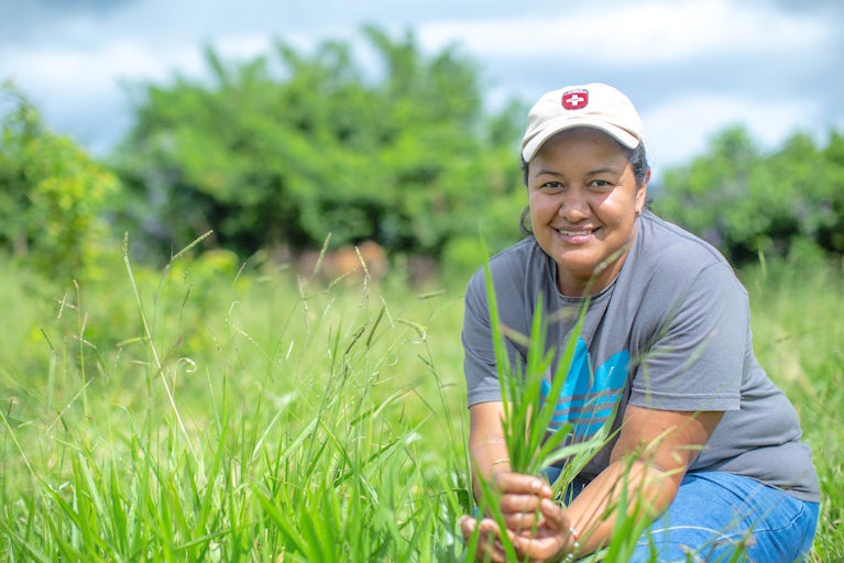 Keyla Aparicio holds and inspect a handful of grass from the pasture.