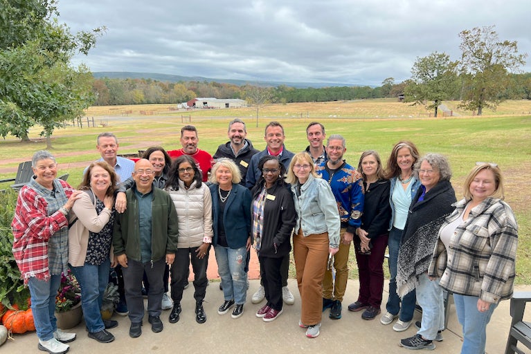Diverse group photo of the Heifer CEO along with the Board of Directors with fields and trees in the background