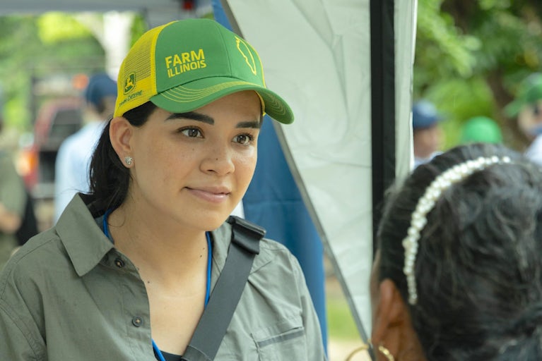 A woman in Mexico wears a John Deer hat