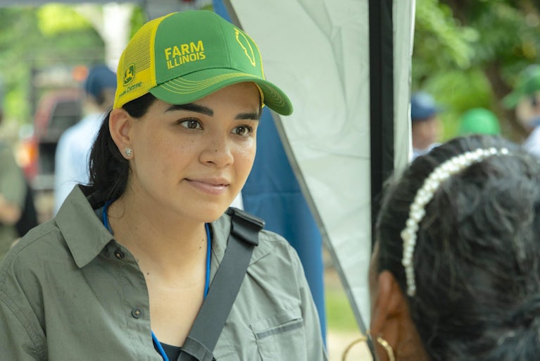 A woman in Mexico wears a John Deer hat