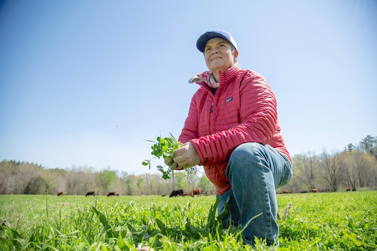 Donna kneeling in a field.