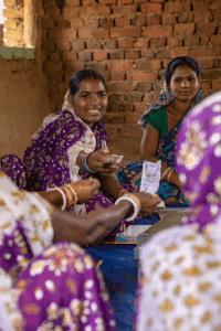A woman hands money to a fellow group member.