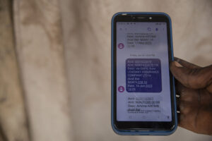 Close-up of a mobile phone screen showing a deposit notification for an insurance payout.