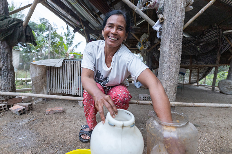 Orn Chanraun changes the water for her chickens in Phneat village, Phsar commune, Kampong Chhnang province, Cambodia.