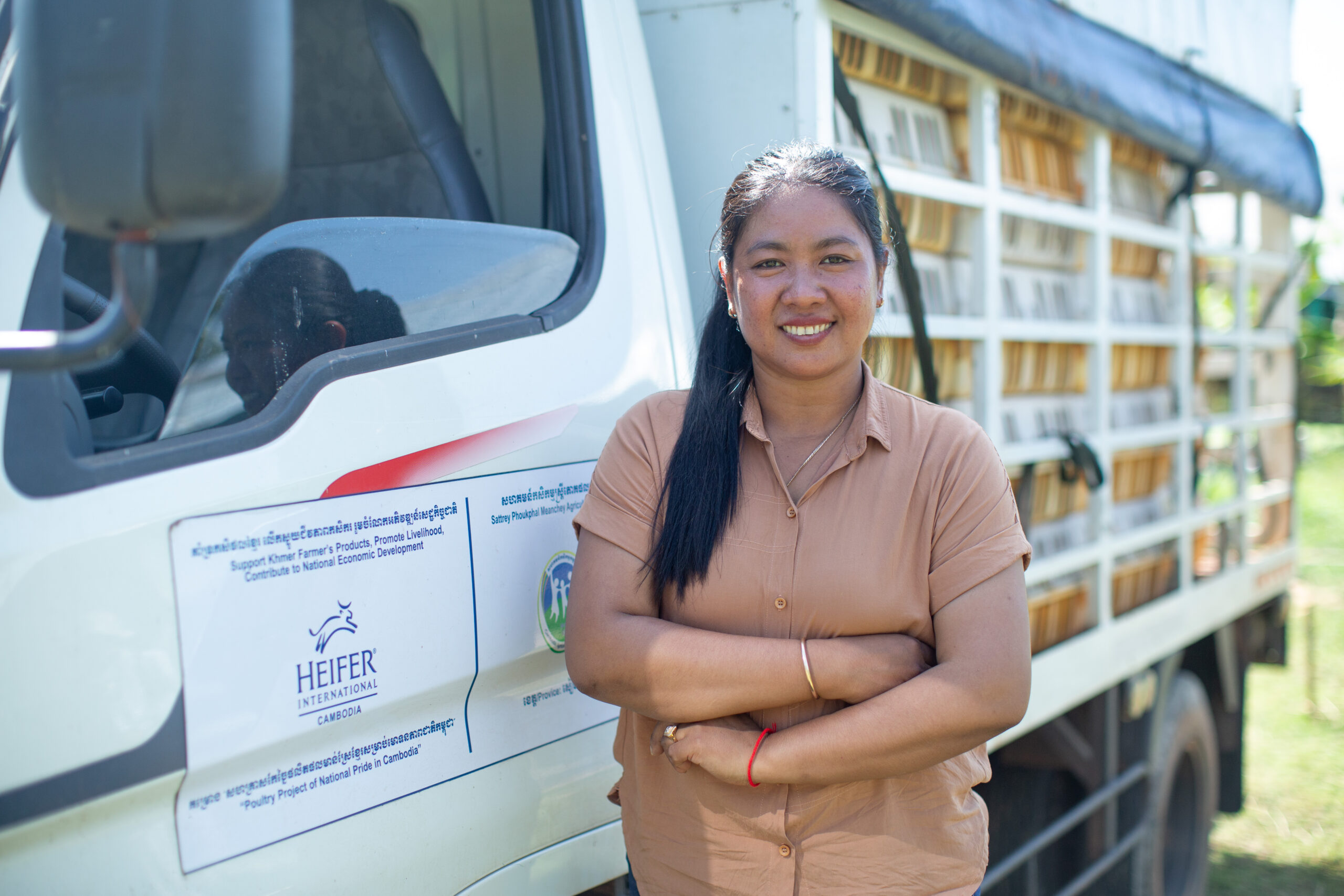 Set Hach stands beside a Heifer International Cambodia poultry transport truck.