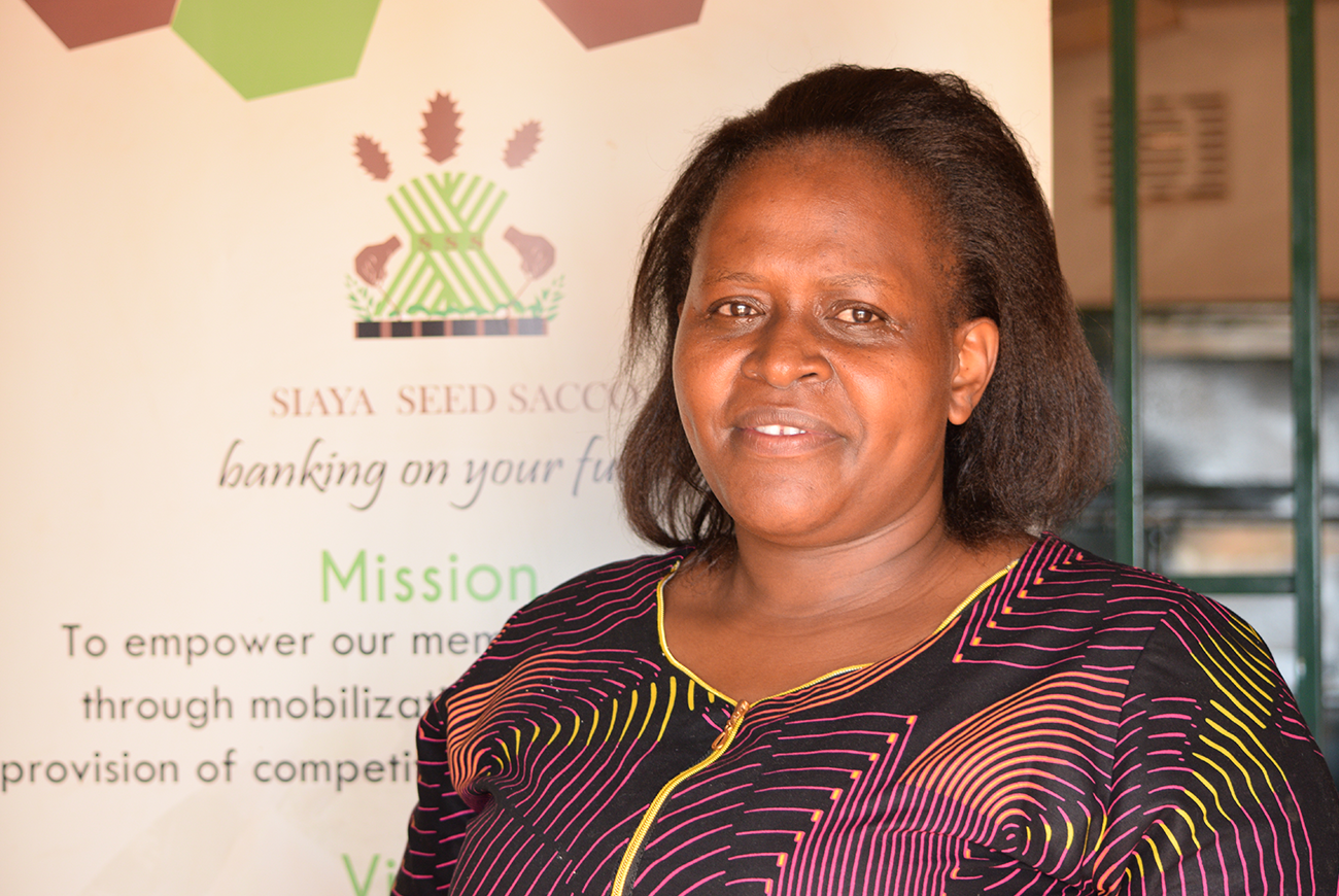 A woman stands in front of a sign in a bank.