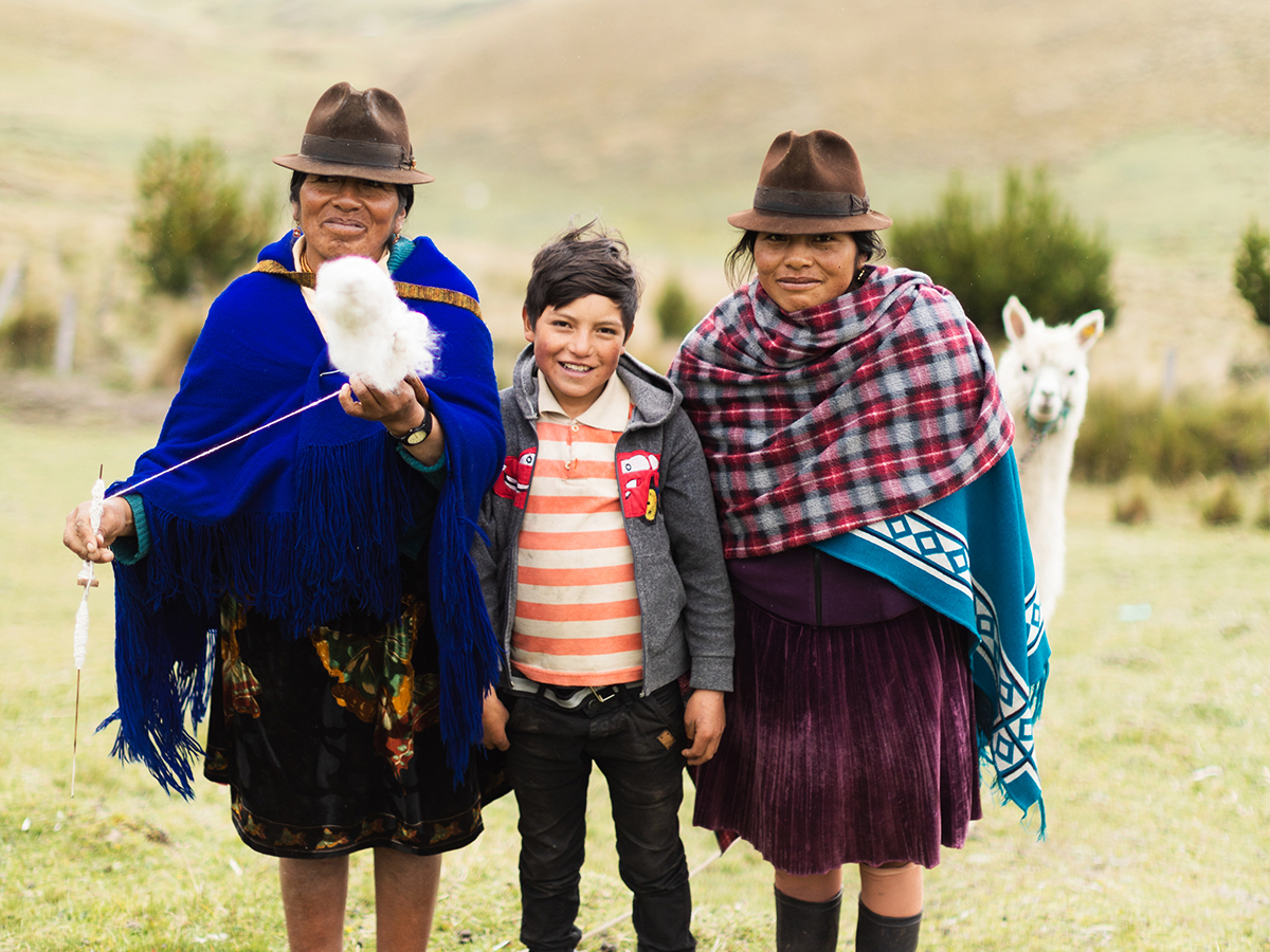 An alpaca sneaks in a family photo of María Juana Chaluisa (49), her nephew Michael (10) and her daughter Inés.