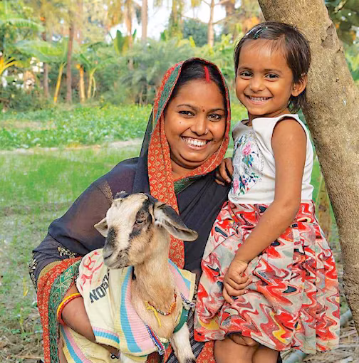 Mother and child holding a goat.