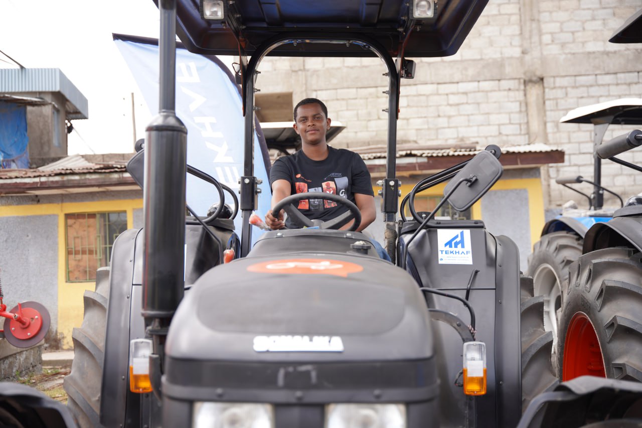 A man sits in the driver’s seat of a tractor.