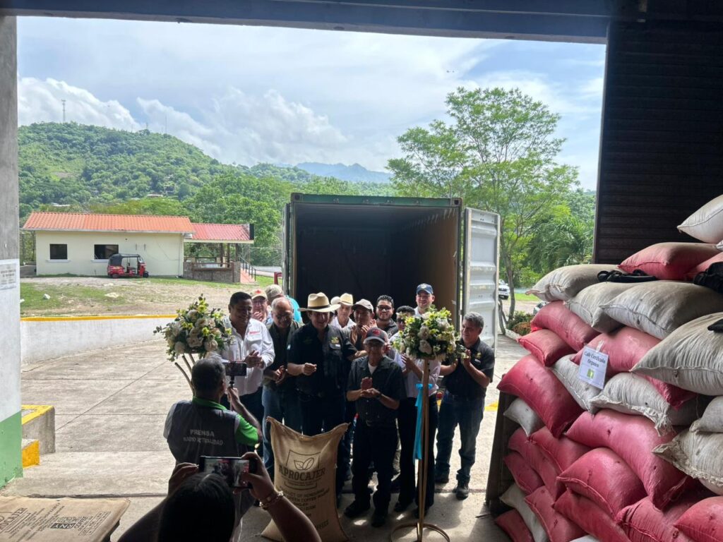 A group of people gathers in front of an open shipping container.