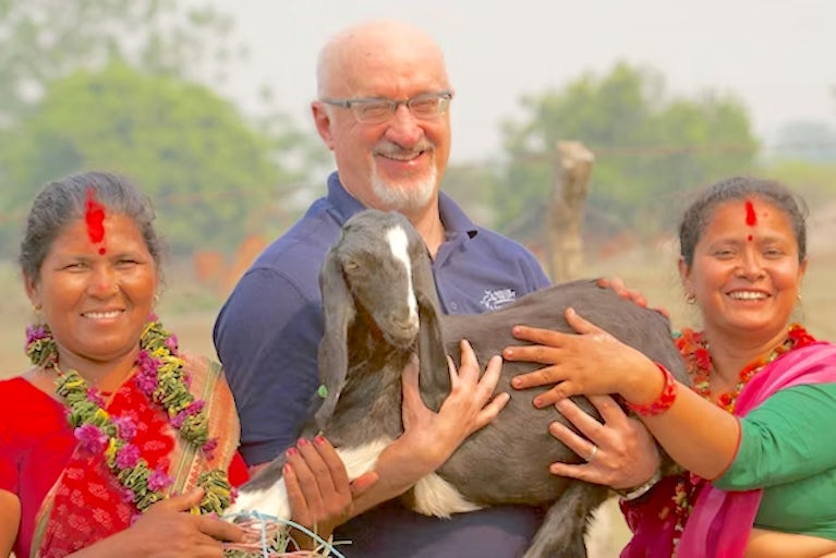 Pierre Ferrari with two women holding a goat.