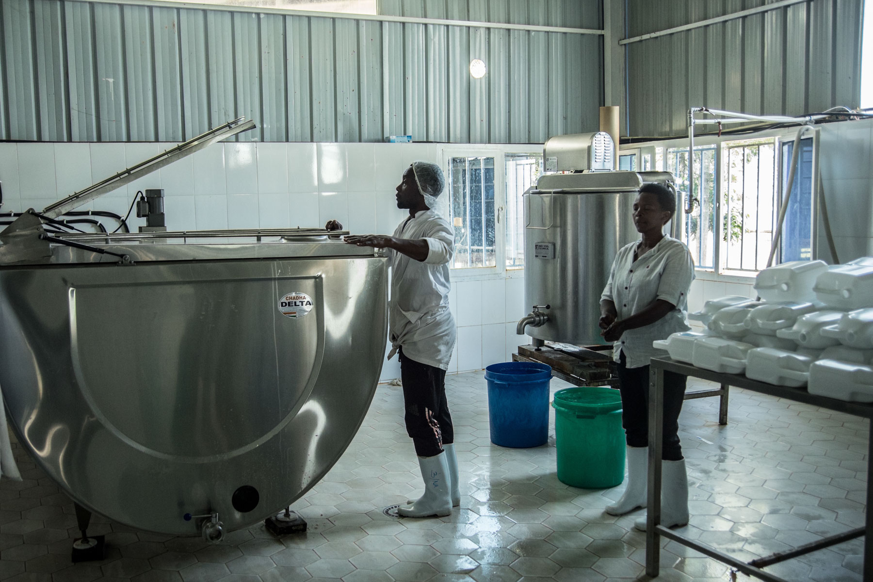Workers at Nyagatare Dairy Cooperative in Rwanda use milk processing equipment to produce yogurt and other dairy products.