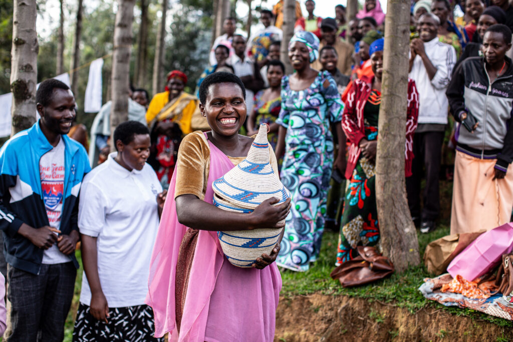 A participant smiles while holding a ceremonial gift.