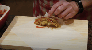Pooi Yin Chong demonstrates how to properly roll a spring roll wrapper.