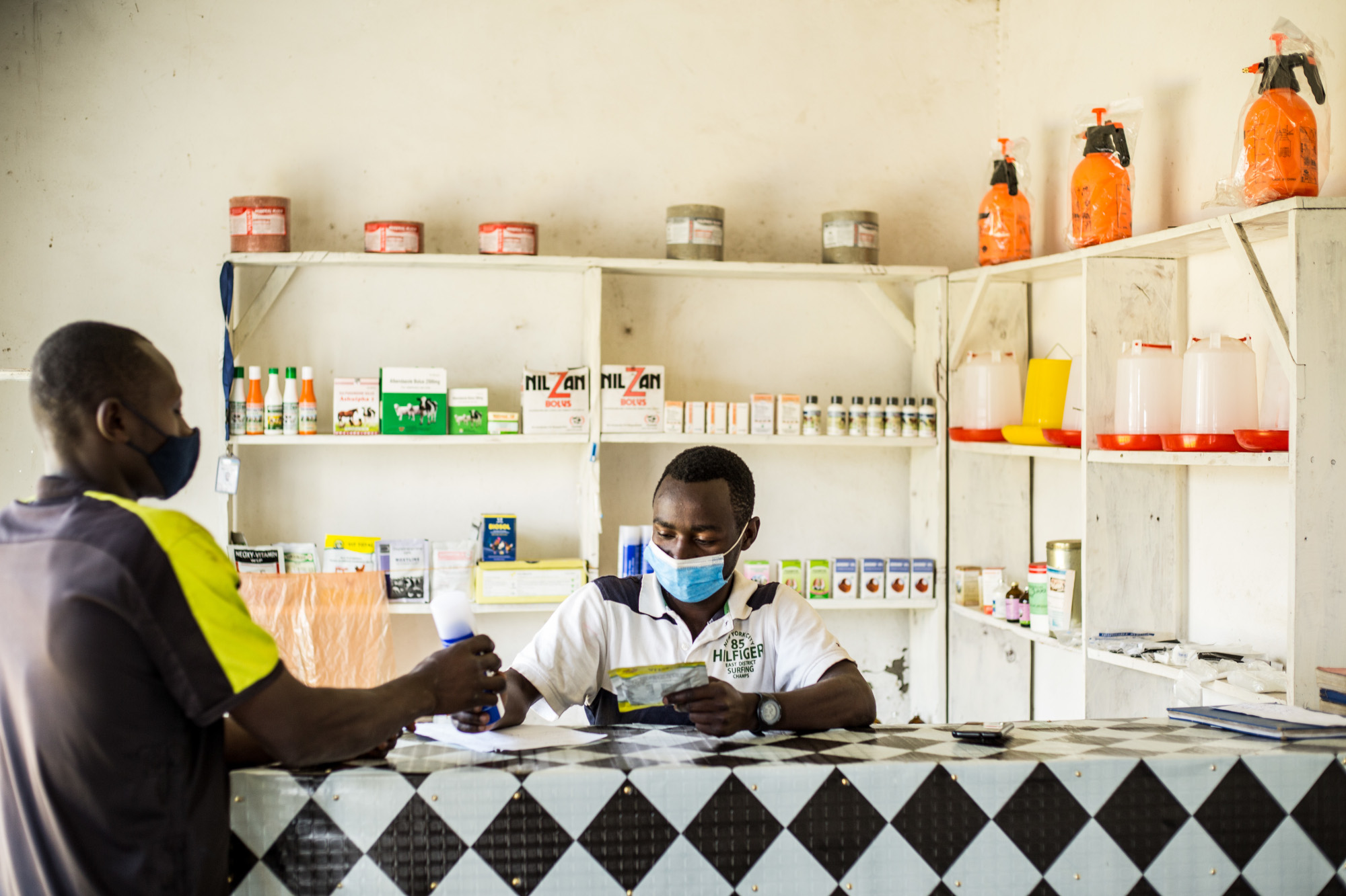 A man selling veterinary drugs to a livestock farmer.
