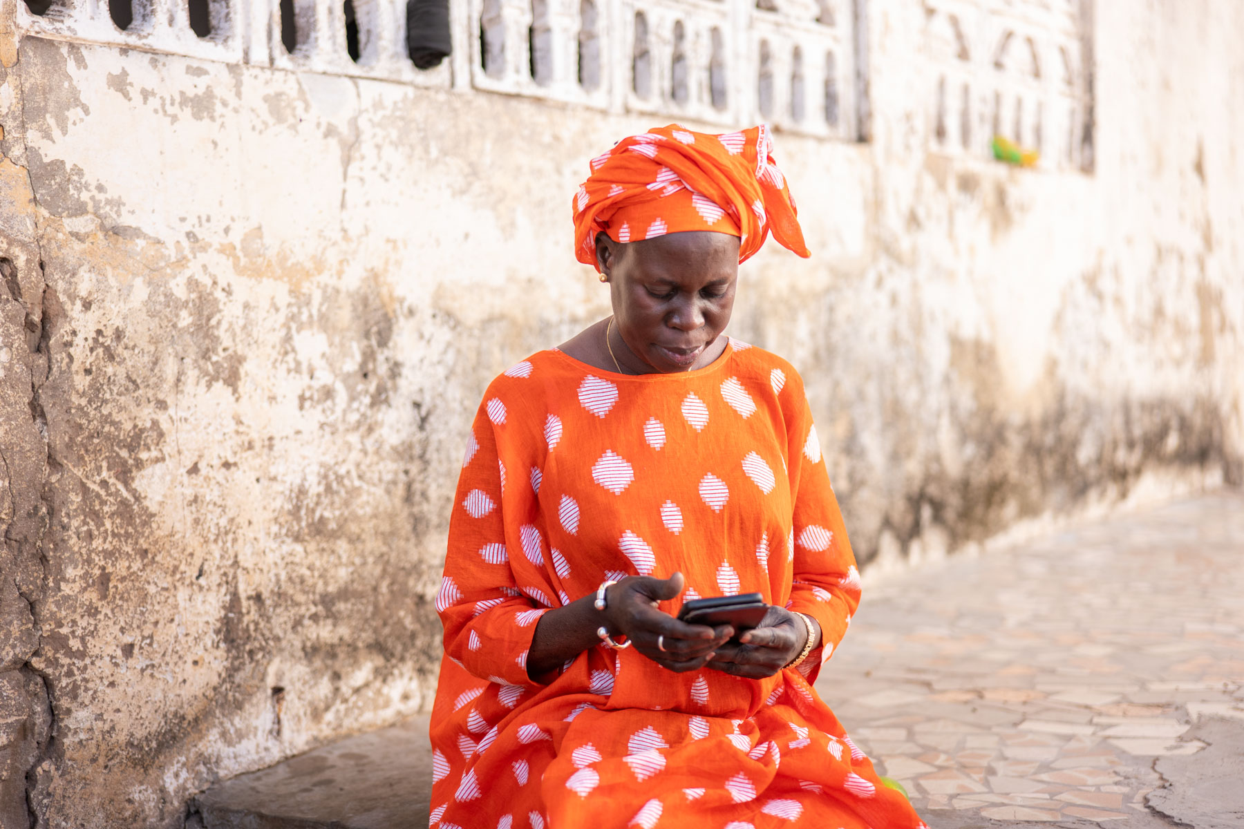 A woman in Senegal checks a weather alert on her phone.