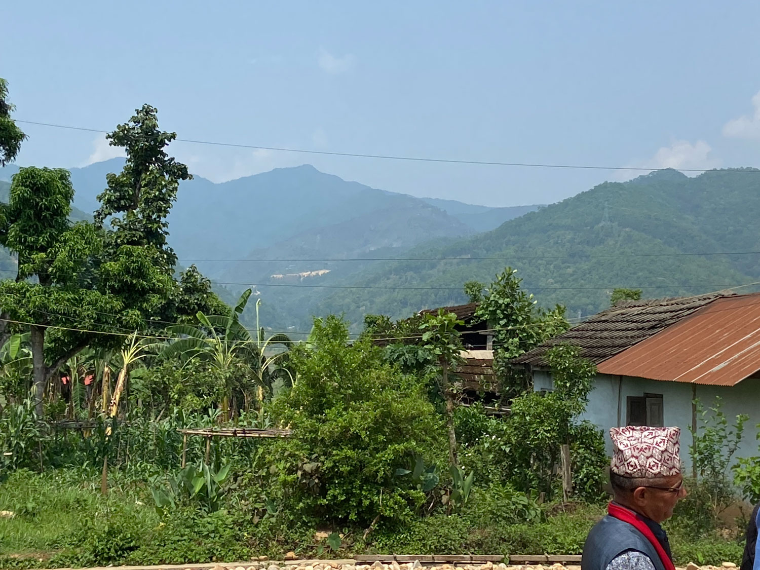 A hilly landscape with green vegetation and distant mountains.
