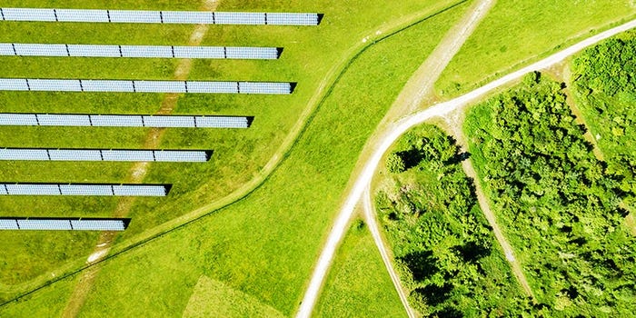 A man installs solar panels on a roof.
