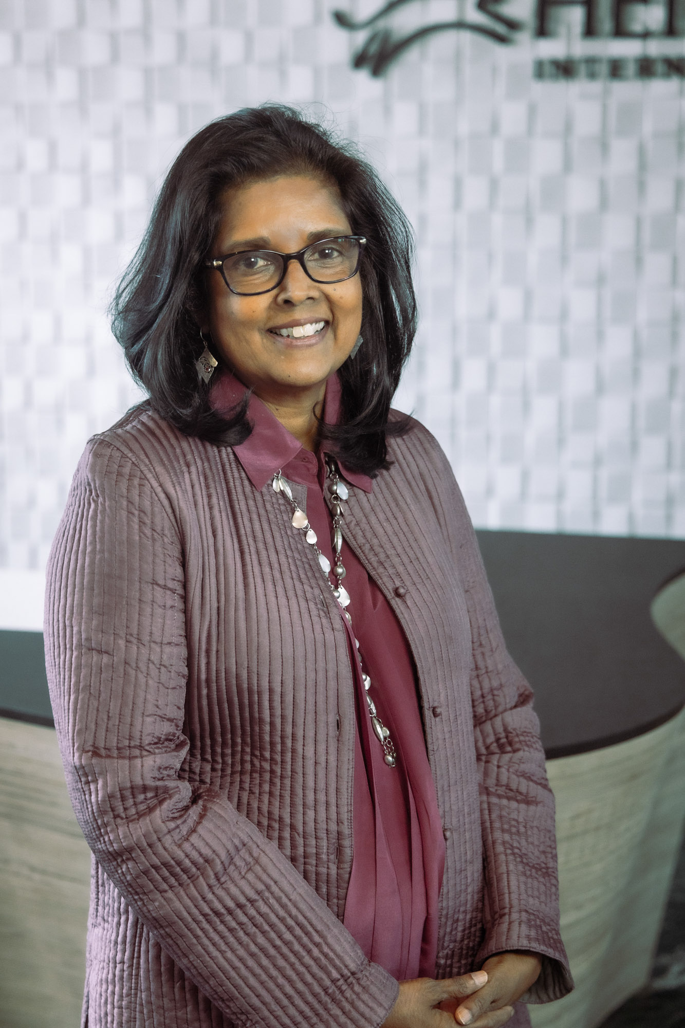 Surita Sandosham, president and CEO of Heifer International, stands with her hands clasped.