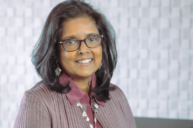 Surita Sandosham, president and CEO of Heifer International, stands with her hands clasped.