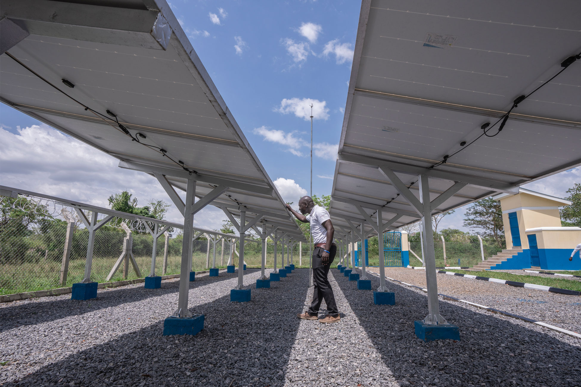 Kennedy Okuu, Heifer Project Coordinator W4DB, inspecting the solar system installed in Mauge village, Lyankonge parish, Dwaniro Subcounty.