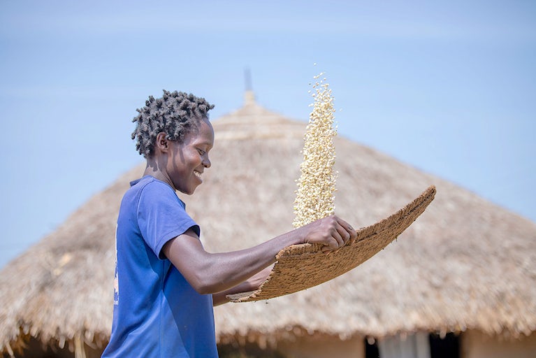 A woman in Uganda holding seeds.