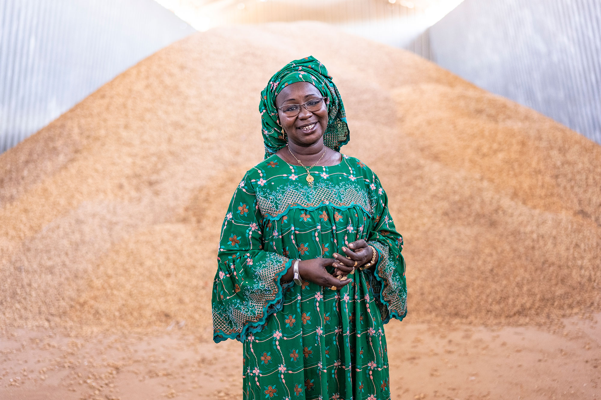 Black woman standing in green dress smiling.