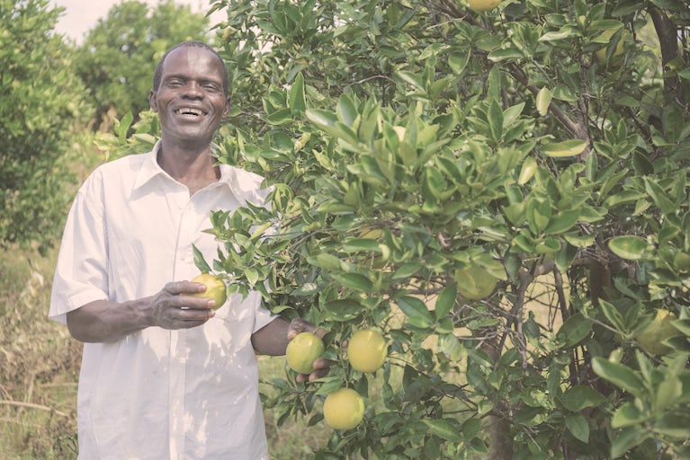 A man stands next to a tree in Zambia.
