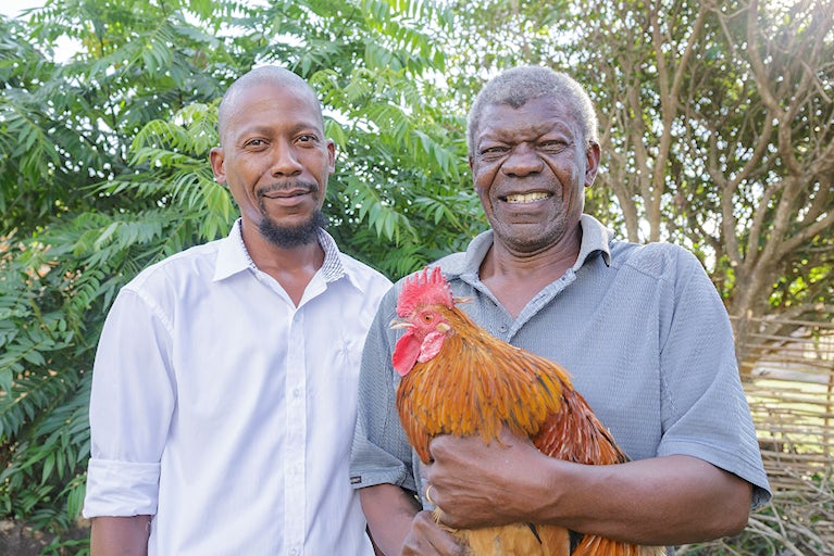 Two men with a chicken.