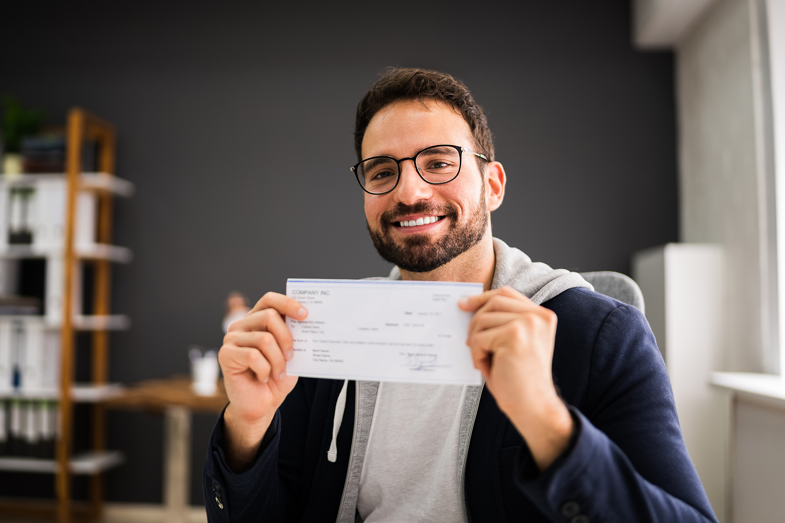 A man holds up his paycheck.