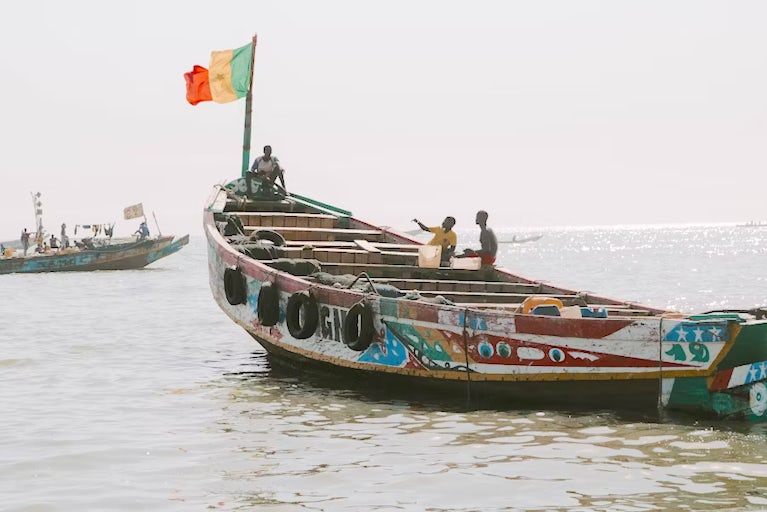 Boat on a river with a flag in the front.