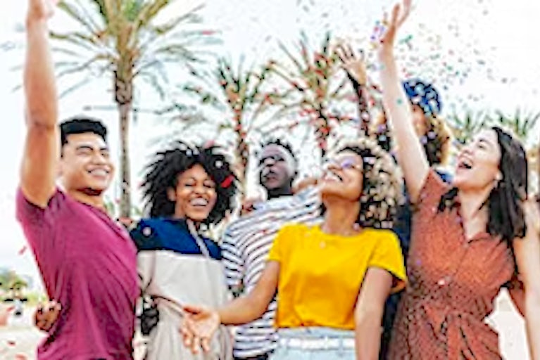Young people standing together and celebrating with confetti.